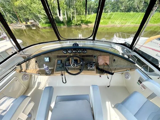 "kimberly Cay" Yacht Photos Pics 2003 Carver 360 Sport Sedan helm with river view, featuring steering wheel and control panel.