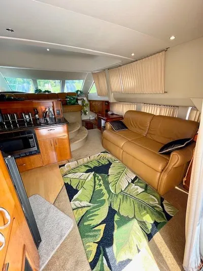 "kimberly Cay" Yacht Photos Pics 2003 Carver 360 Sport Sedan interior with leather sofa, kitchen, and tropical rug.