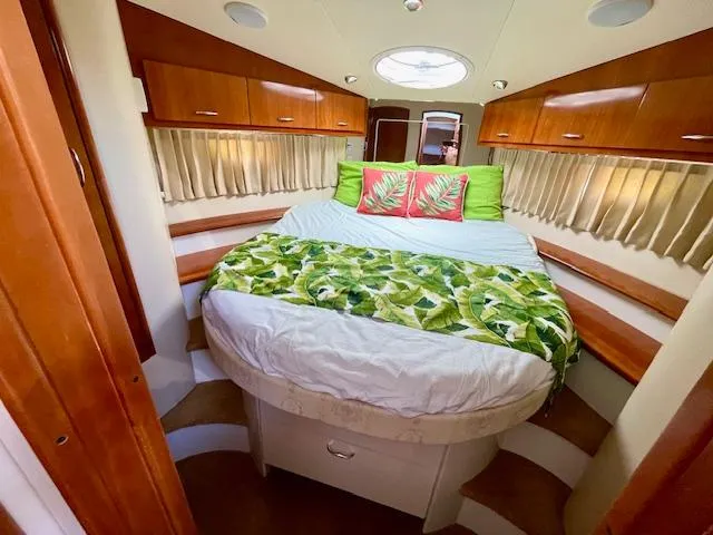 "kimberly Cay" Yacht Photos Pics 2003 Carver 360 Sport Sedan bedroom with tropical decor and wooden cabinetry.