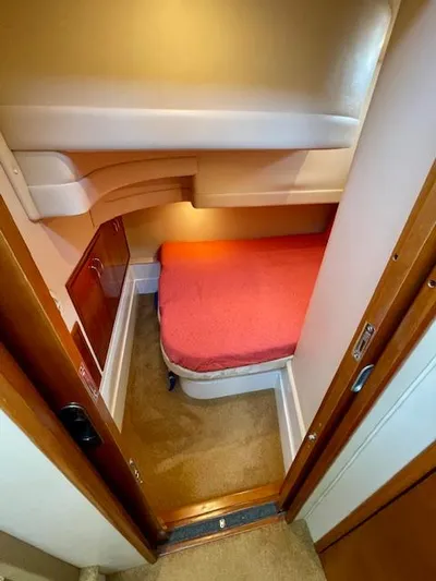 "kimberly Cay" Yacht Photos Pics Cozy cabin interior of 2003 Carver 360 Sport Sedan with red bedding and wood accents.
