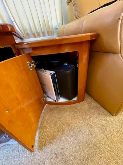 "kimberly Cay" Yacht Photos Pics Open wooden cabinet in 2003 Carver 360 Sport Sedan, revealing storage with books and a briefcase.