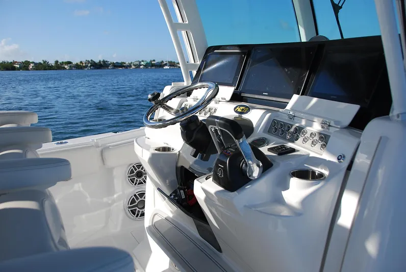  Yacht Photos Pics 2019 HCB 39 Speciale boat cockpit with steering wheel and control panel, overlooking calm waters.