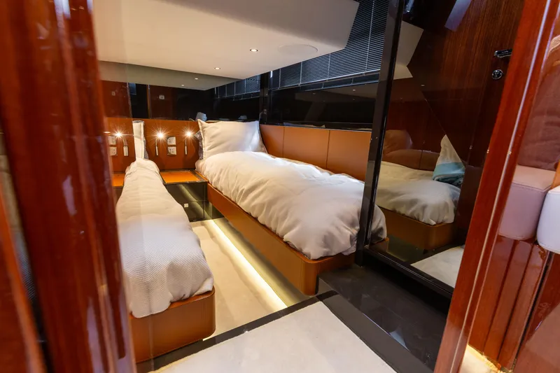  Yacht Photos Pics Luxurious 2022 Riva Dolceriva yacht cabin with twin beds and elegant wood finishes.