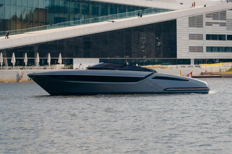  Yacht Photos Pics 2022 Riva Dolceriva luxury yacht cruising near modern architecture.