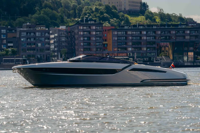  Yacht Photos Pics 2022 Riva Dolceriva luxury yacht cruising on a river with urban backdrop.