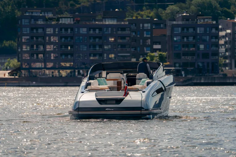  Yacht Photos Pics 2022 Riva Dolceriva luxury yacht cruising on a sunny day near urban waterfront.
