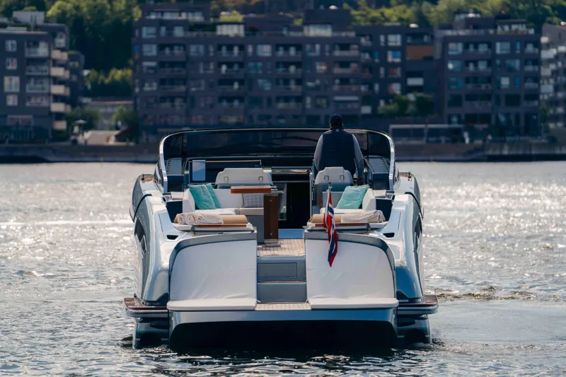  Yacht Photos Pics 2022 Riva Dolceriva luxury yacht cruising on a sunny day, with cityscape in the background.