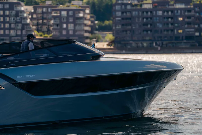  Yacht Photos Pics 2022 Riva Dolceriva luxury yacht cruising on a sunny day near urban waterfront.