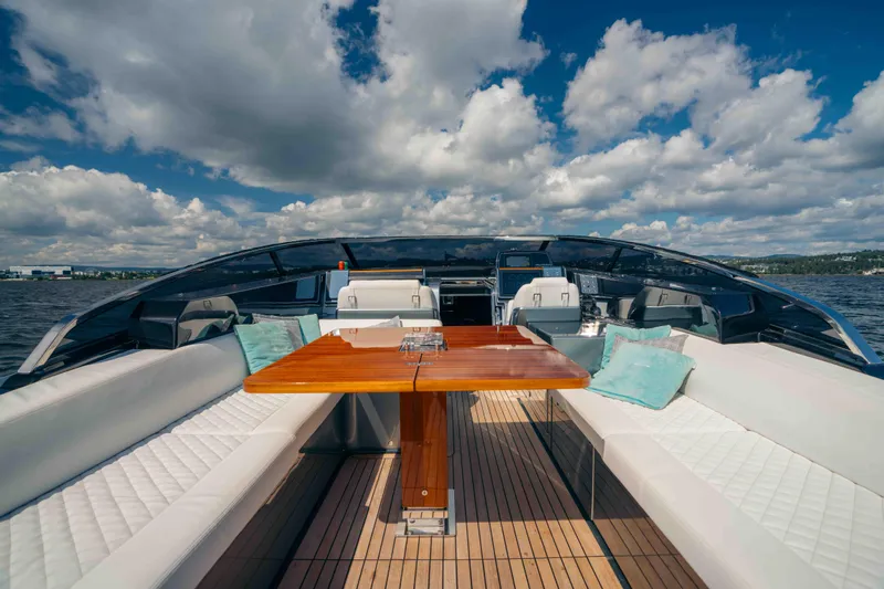  Yacht Photos Pics Luxurious 2022 Riva Dolceriva yacht with elegant seating and wooden table on deck.