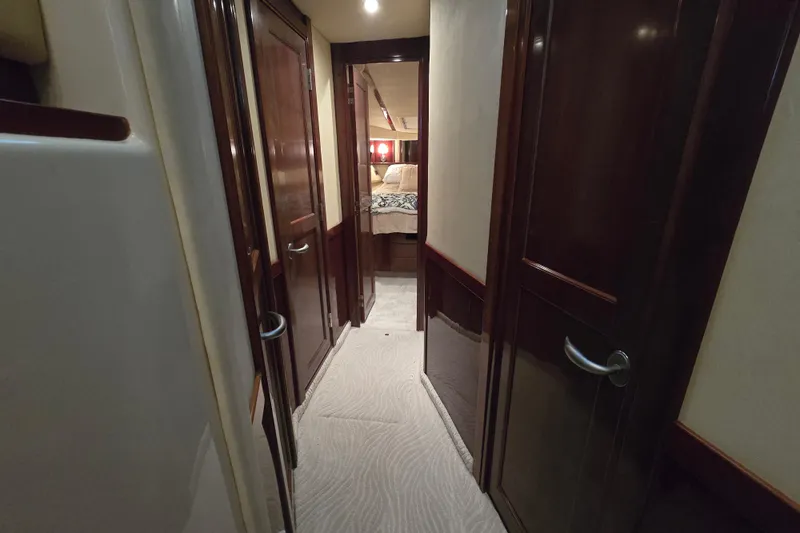 Verdee Yacht Photos Pics Interior hallway of 2007 Sea Ray 52 Sedan Bridge yacht with wooden doors and carpet.