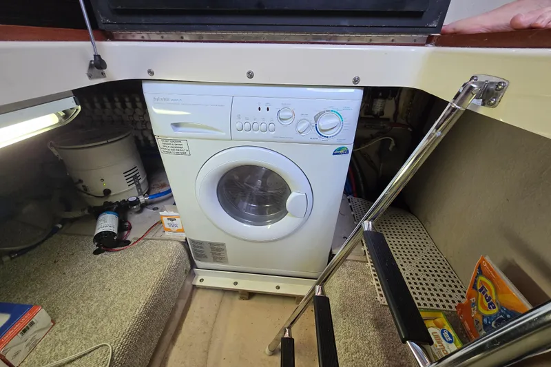Verdee Yacht Photos Pics Laundry area with a washing machine inside a 2007 Sea Ray 52 Sedan Bridge yacht.