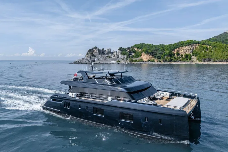 Petite Belle Yacht Photos Pics Luxurious 2025 Sunreef 100 Power yacht cruising near scenic coastline.