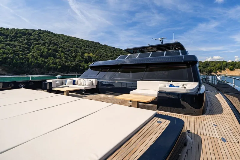 Petite Belle Yacht Photos Pics Luxurious Sunreef 100 Power yacht deck with seating, 2025 model, surrounded by scenic coastal views.
