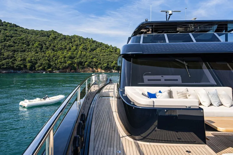 Petite Belle Yacht Photos Pics Luxurious 2025 Sunreef 100 Power yacht with elegant deck, scenic ocean view, and lush green backdrop.