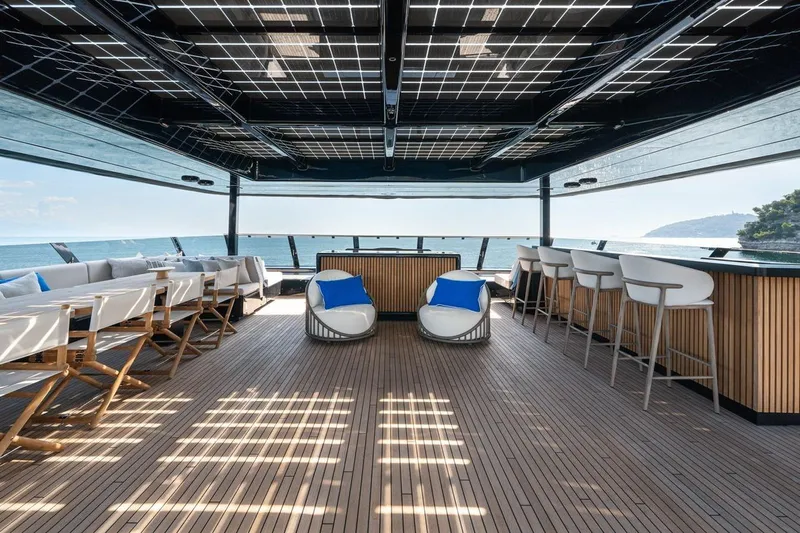 Petite Belle Yacht Photos Pics Luxurious Sunreef 100 Power yacht deck with seating, bar, and ocean view, 2025 model.