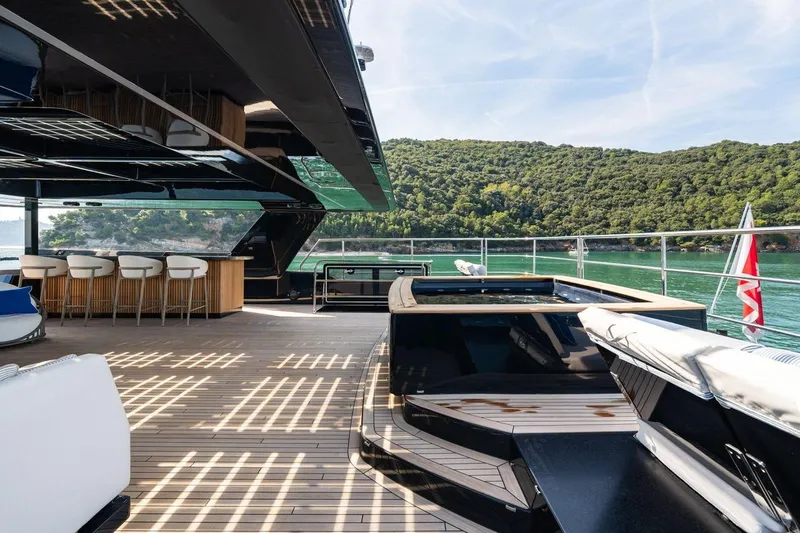 Petite Belle Yacht Photos Pics Luxurious Sunreef 100 Power yacht deck with bar, seating, and scenic ocean view, 2025 model.