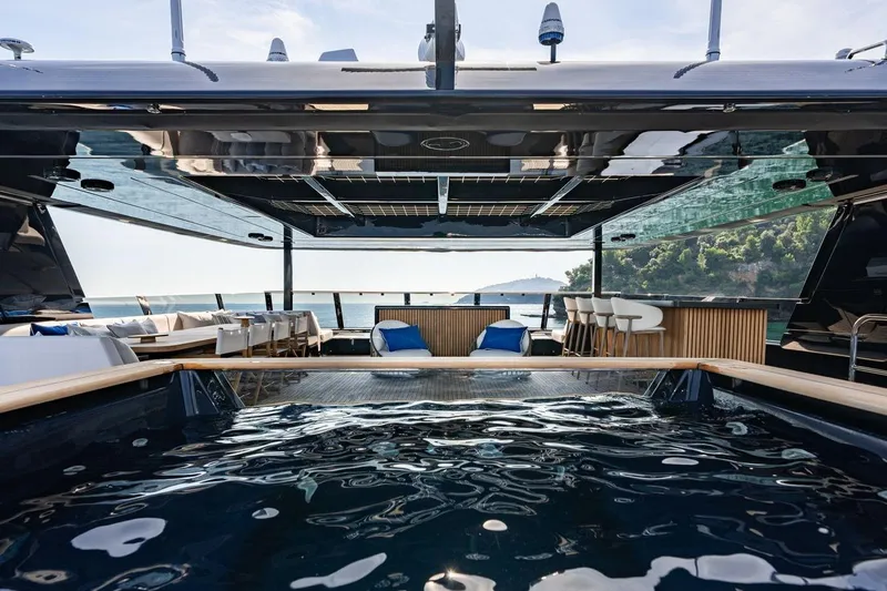 Petite Belle Yacht Photos Pics Luxurious Sunreef 100 Power yacht interior with pool, bar, and ocean view, 2025 model.