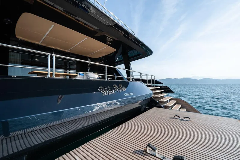 Petite Belle Yacht Photos Pics Luxurious 2025 Sunreef 100 Power yacht docked, featuring sleek design and spacious deck.