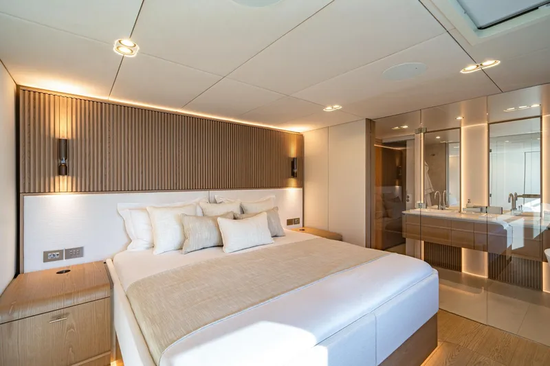 Petite Belle Yacht Photos Pics Luxurious bedroom interior of 2025 Sunreef 100 Power yacht, featuring modern design and elegant lighting.
