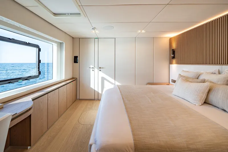 Petite Belle Yacht Photos Pics Luxurious Sunreef 100 Power 2025 yacht bedroom with ocean view and elegant decor.