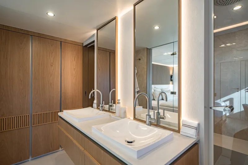 Petite Belle Yacht Photos Pics Luxurious bathroom on 2025 Sunreef 100 Power yacht with dual sinks and modern wood accents.