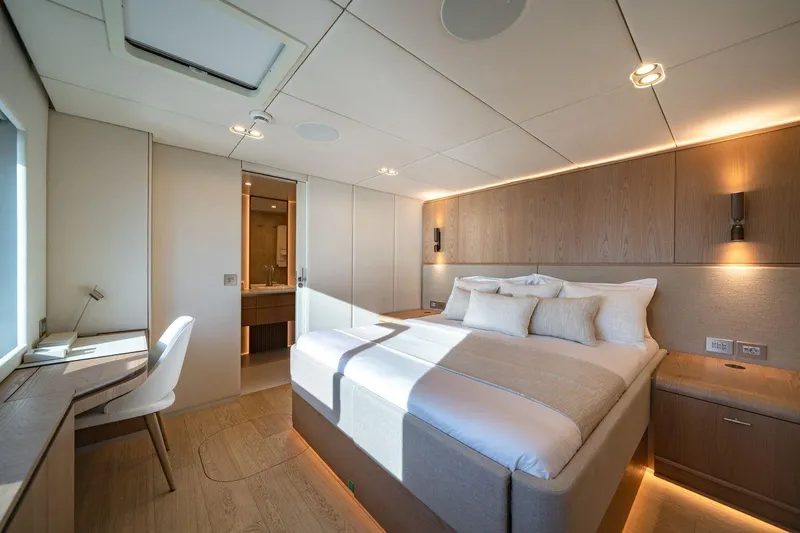 Petite Belle Yacht Photos Pics Luxurious Sunreef 100 Power 2025 yacht bedroom with modern design and natural lighting.