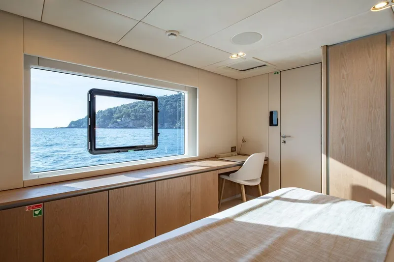 Petite Belle Yacht Photos Pics Luxurious Sunreef 100 Power 2025 yacht cabin with ocean view and modern interior design.