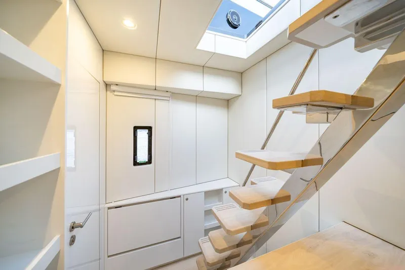 Petite Belle Yacht Photos Pics Modern interior of 2025 Sunreef 100 Power yacht with sleek staircase and skylight.