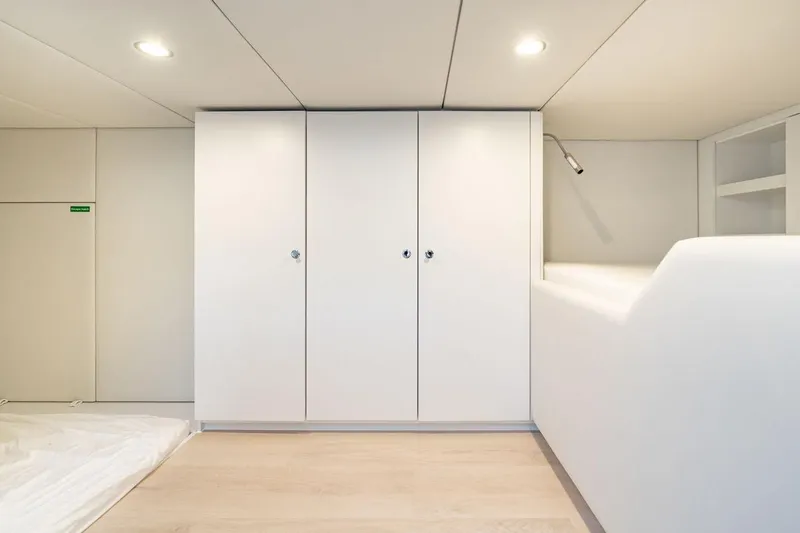 Petite Belle Yacht Photos Pics Minimalist interior of 2025 Sunreef 100 Power yacht with sleek white cabinetry.