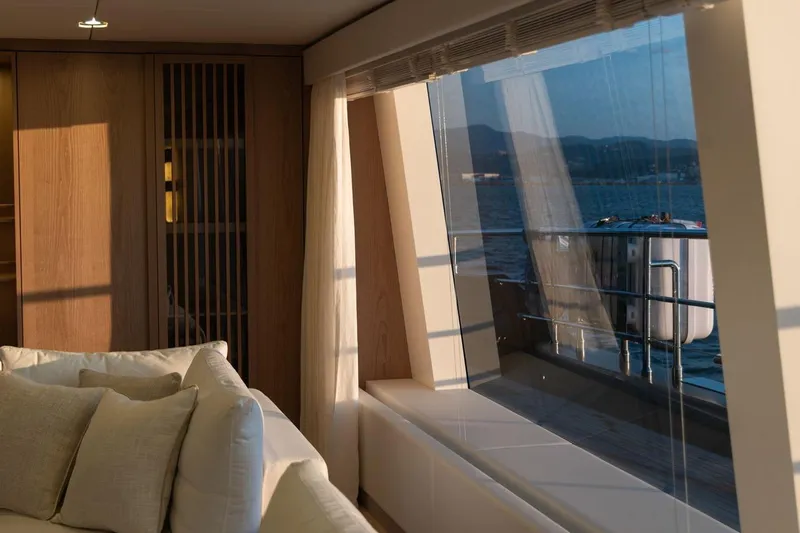 Petite Belle Yacht Photos Pics Luxurious interior of 2025 Sunreef 100 Power yacht with ocean view through large window.