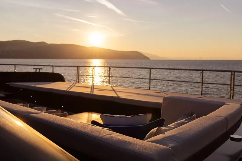 Petite Belle Yacht Photos Pics Luxurious Sunreef 100 Power yacht deck at sunset, 2025 model, overlooking serene ocean.