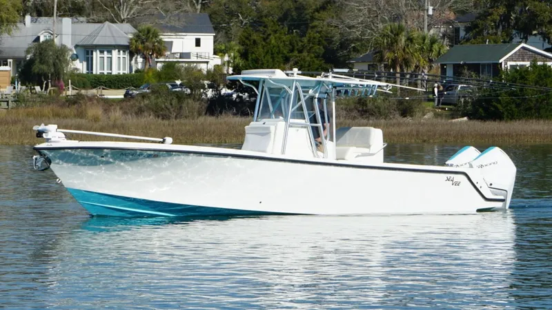  Yacht Photos Pics 2017 SeaVee 320B boat on calm water, with coastal homes in the background.