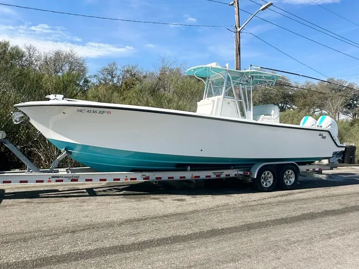  Yacht Photos Pics 2017 SeaVee 320B boat on trailer, white and teal, parked roadside.