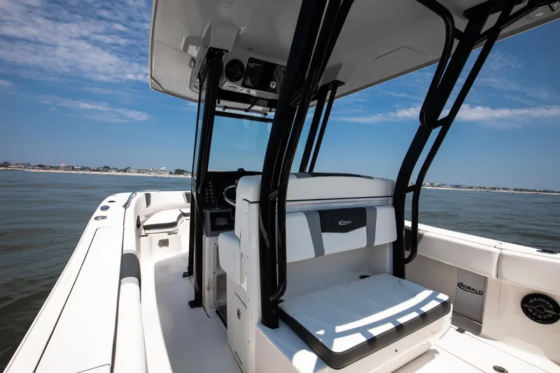  Yacht Photos Pics 2023 Robalo R270 Center Console boat on calm water, featuring sleek design and spacious seating.