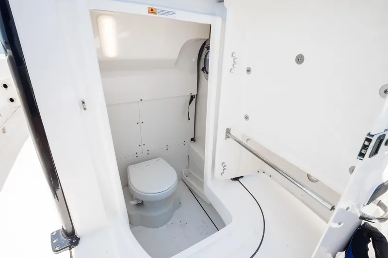  Yacht Photos Pics 2023 Robalo R270 Center Console boat interior with compact marine toilet.