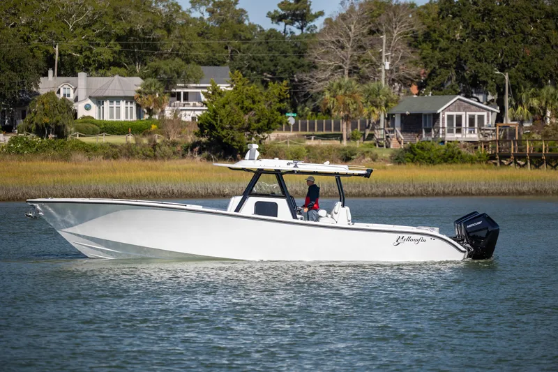  Yacht Photos Pics 2026 Yellowfin 39 Offshore boat cruising on a calm river near residential area.