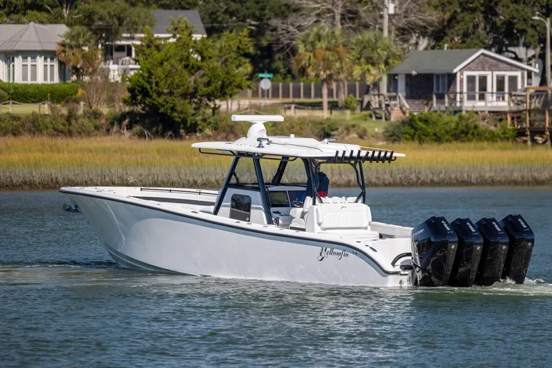  Yacht Photos Pics 2026 Yellowfin 39 Offshore boat cruising on a calm river near houses.