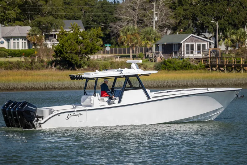  Yacht Photos Pics 2026 Yellowfin 39 Offshore boat cruising on a calm river near waterfront homes.