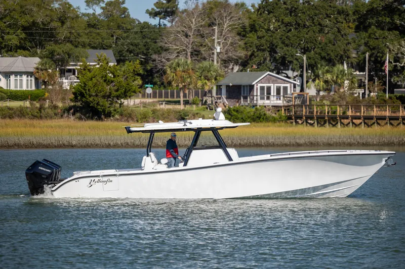  Yacht Photos Pics 2026 Yellowfin 39 Offshore boat cruising on a calm river near a scenic shoreline.