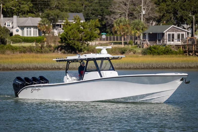  Yacht Photos Pics 2026 Yellowfin 39 Offshore boat cruising on a calm river near waterfront homes.