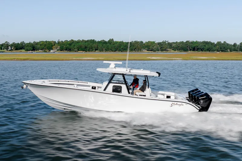  Yacht Photos Pics 2026 Yellowfin 39 Offshore boat cruising on a calm lake with lush green shoreline.
