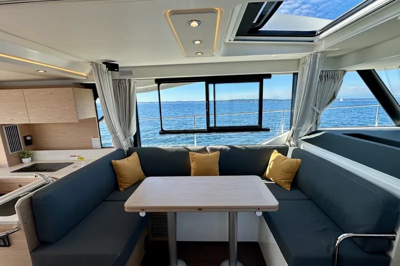 Fret Knot Yacht Photos Pics Interior of 2024 Beneteau Swift Trawler 41 Sedan with ocean view and cozy seating area.