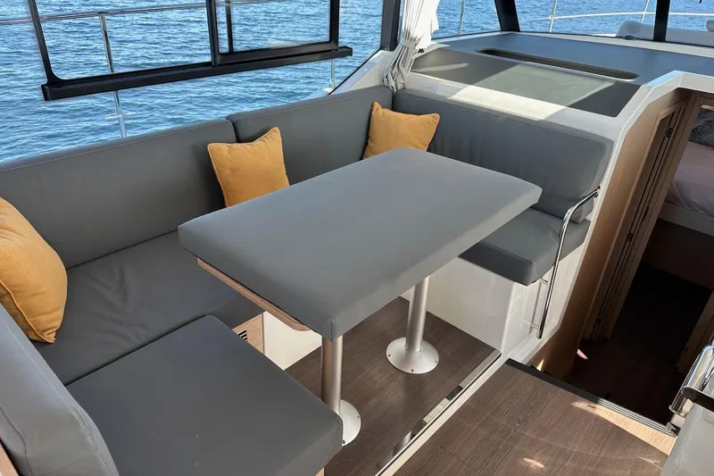 Fret Knot Yacht Photos Pics 2024 Beneteau Swift Trawler 41 Sedan interior with gray seating and table, ocean view.