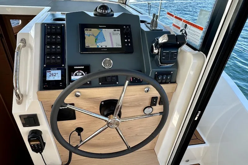 Fret Knot Yacht Photos Pics 2024 Beneteau Swift Trawler 41 Sedan helm with navigation controls and steering wheel.