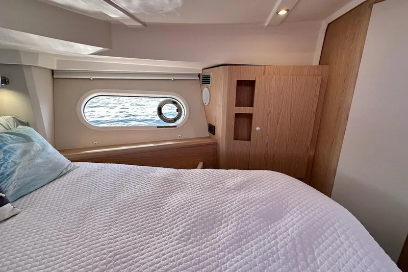 Fret Knot Yacht Photos Pics 2024 Beneteau Swift Trawler 41 Sedan cabin with bed, window, and wooden cabinetry.