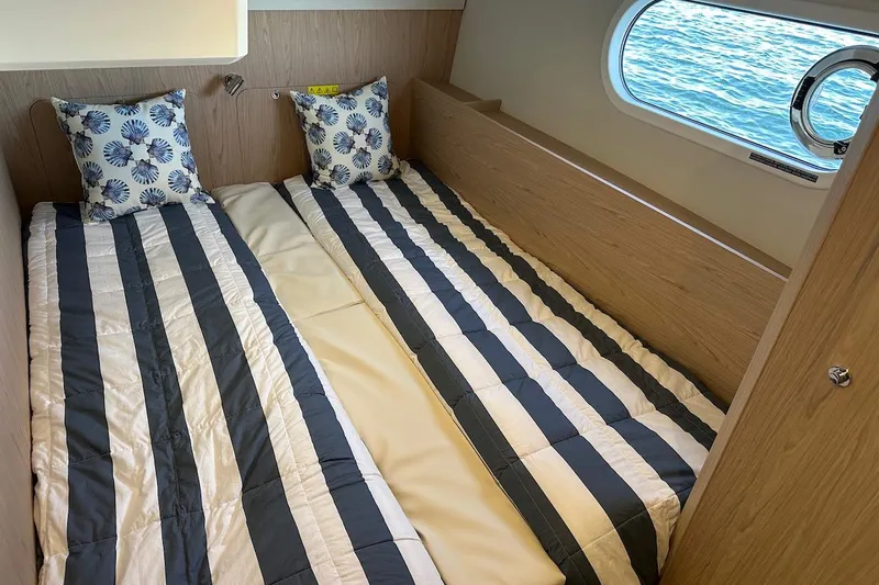 Fret Knot Yacht Photos Pics 2024 Beneteau Swift Trawler 41 Sedan cabin with twin beds and nautical-themed decor.