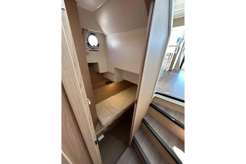 Fret Knot Yacht Photos Pics Interior view of 2024 Beneteau Swift Trawler 41 Sedan, featuring wooden stairs and compact cabin.