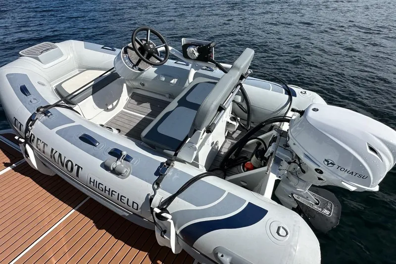 Fret Knot Yacht Photos Pics Inflatable boat with Tohatsu motor on water, associated with 2024 Beneteau Swift Trawler 41 Sedan.