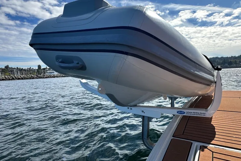 Fret Knot Yacht Photos Pics 2024 Beneteau Swift Trawler 41 Sedan with mounted dinghy on deck, ocean backdrop.