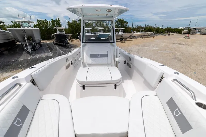  Yacht Photos Pics 2026 Sea Fox 268 Commander boat interior with white seating and console, parked outdoors.